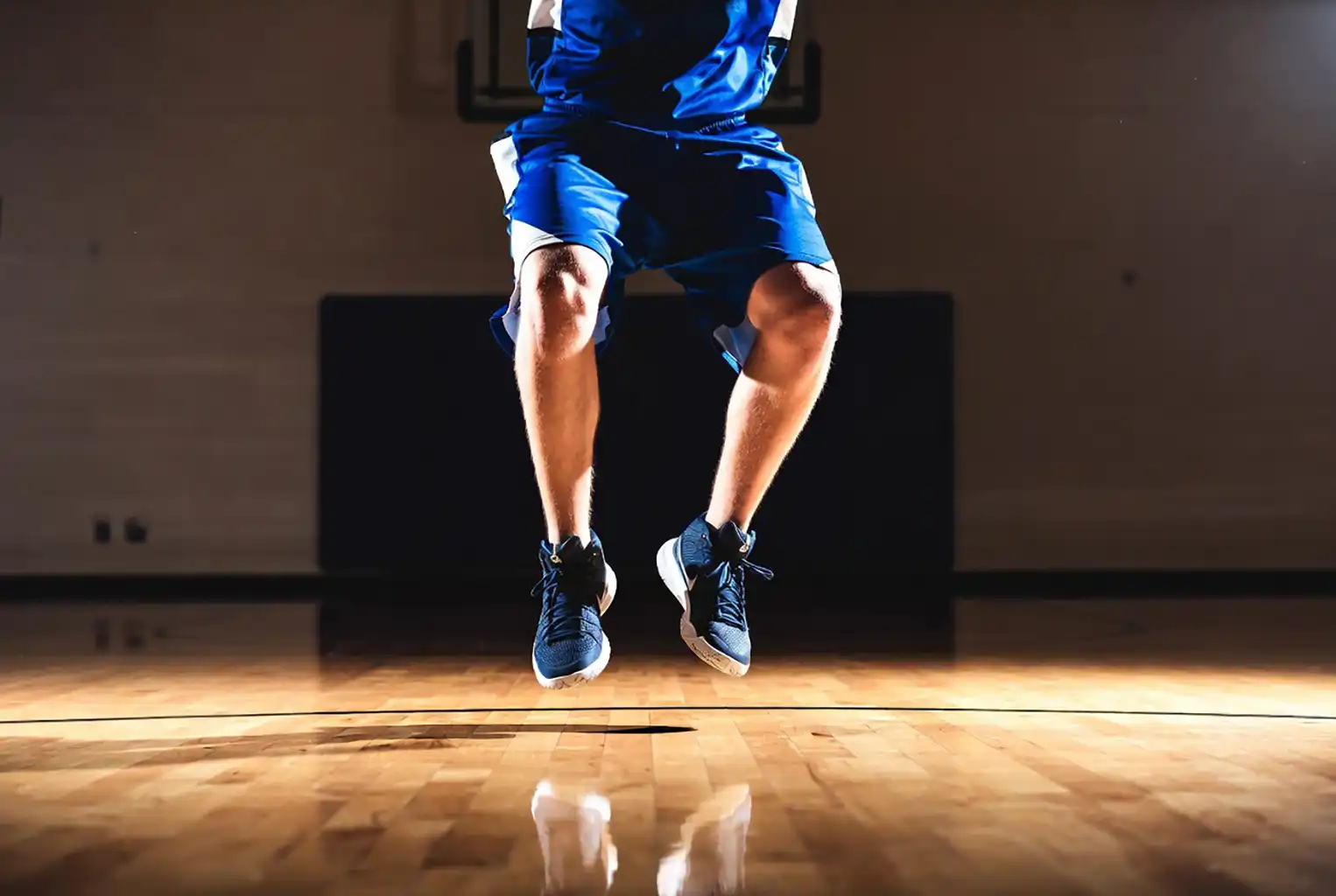 high school basketball player landing with proper mechanics knees aligned over toes to prevent ACL injury